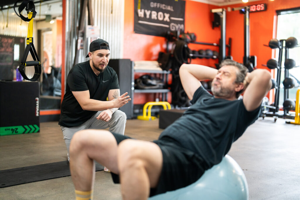 Isaac training Joe on a ballast ball during a personal training session at The Energy Lab in Redlands, CA.