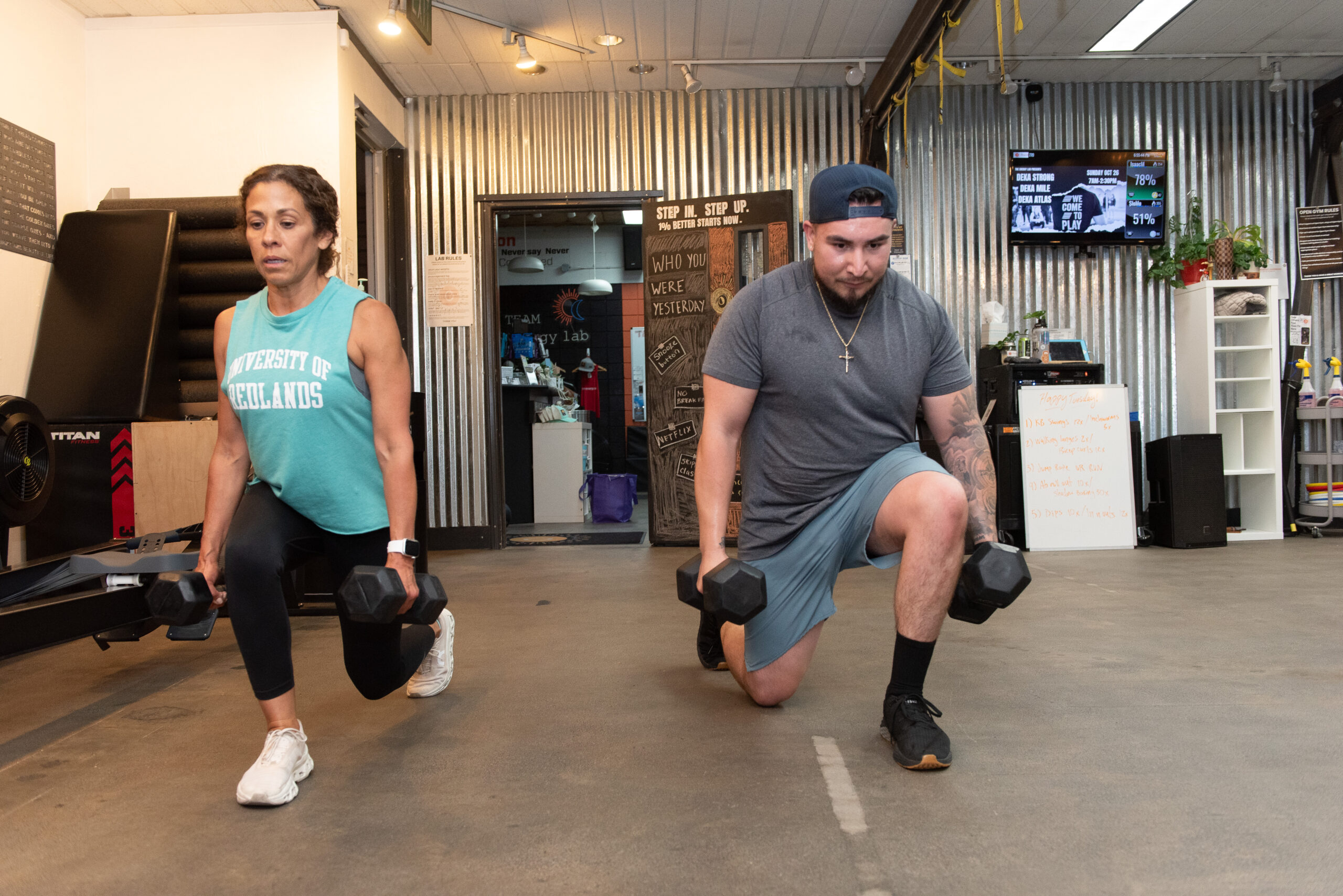 Isaac doing a lunge with dumbbells during Circuit Strength group fitness class at The Energy Lab in Redlands, CA.