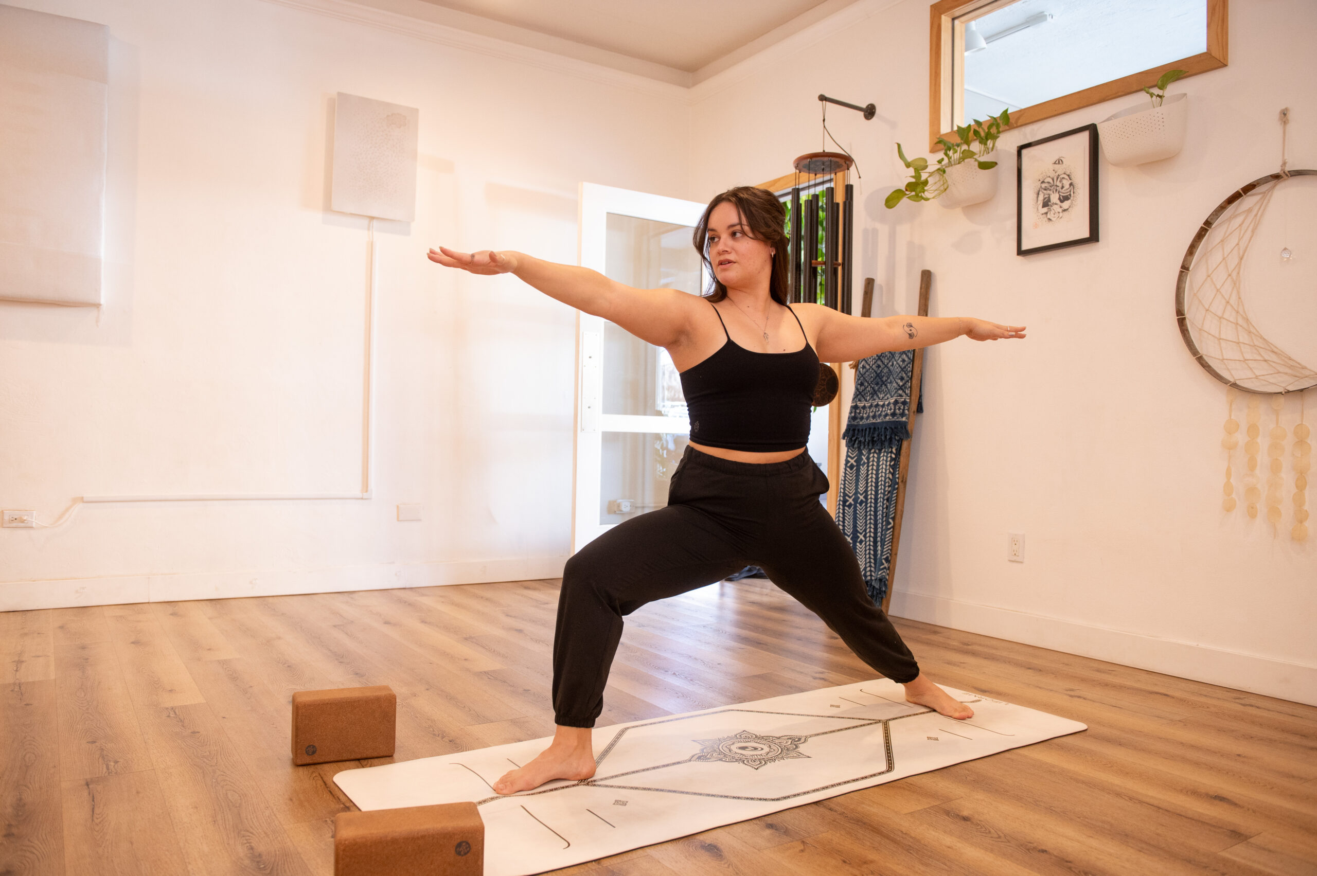 Jacquelyn doing a Warrior 2 Pose in the yoga space at The Energy Lab in Redlands, CA.
