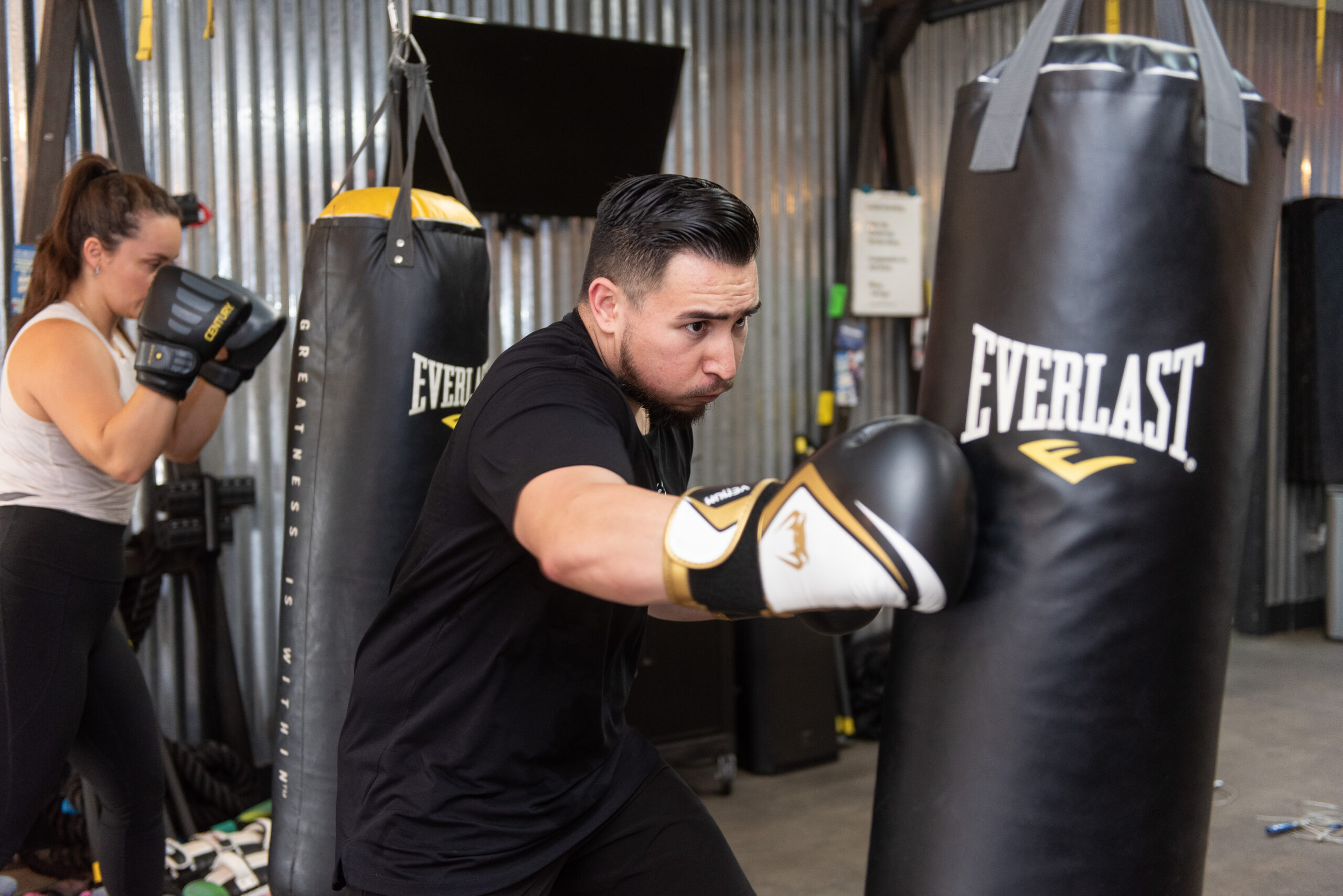 Isaac punching a heavy bag during a group fitness class at The Energy Lab in Redlands, CA.