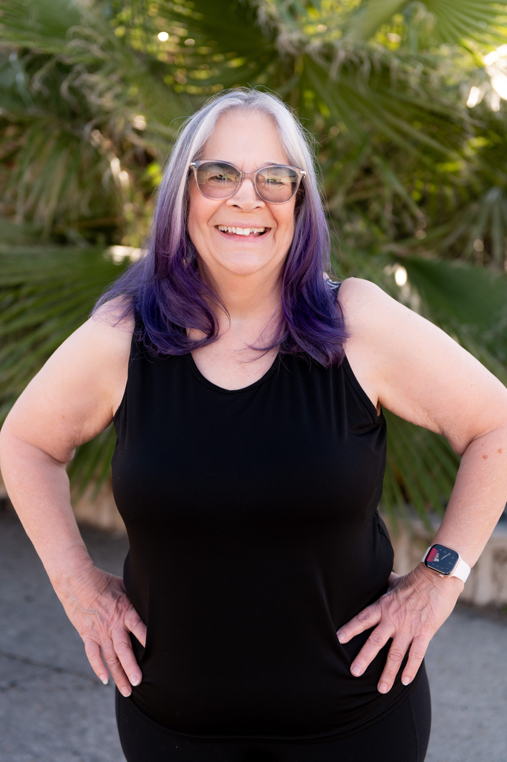 Germaine, personal trainer and group fitness instructor at The Energy Lab in Redlands, CA, smiling outdoors with hands on hips.