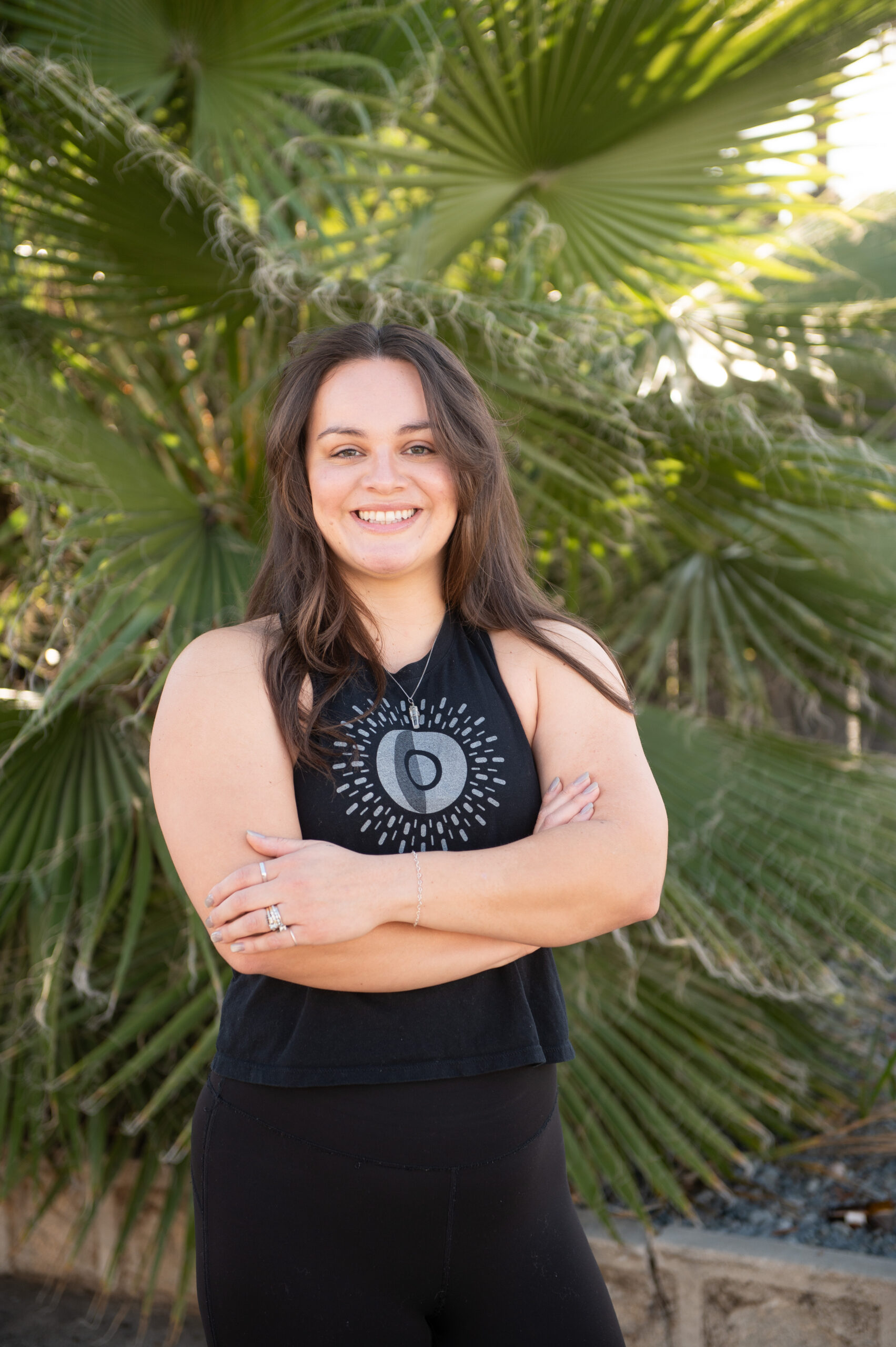 Jacquelyn, personal trainer, yoga instructor, and group fitness coach at The Energy Lab in Redlands, CA, standing outdoors and smiling with arms crossed.