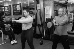 Lauren and Bob doing kettlebell swings during Circuit Strength class at The Energy Lab in Redlands, CA