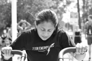 Jasmeen riding an Assault Bike in a Hybrid Training class at The Energy Lab in Redlands, CA