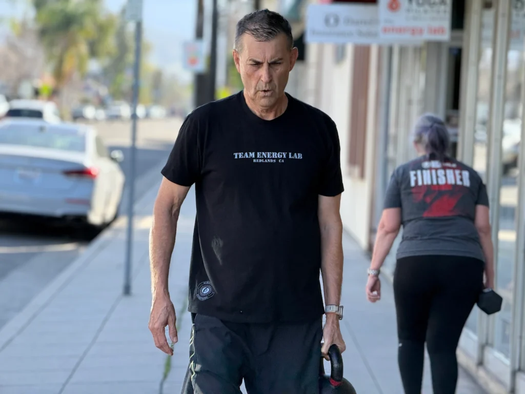 Bob performing a Farmer Carry during a group fitness class at The Energy Lab in Redlands, CA.